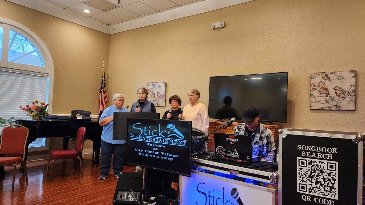 A group of people singing karaoke at an indoor event.