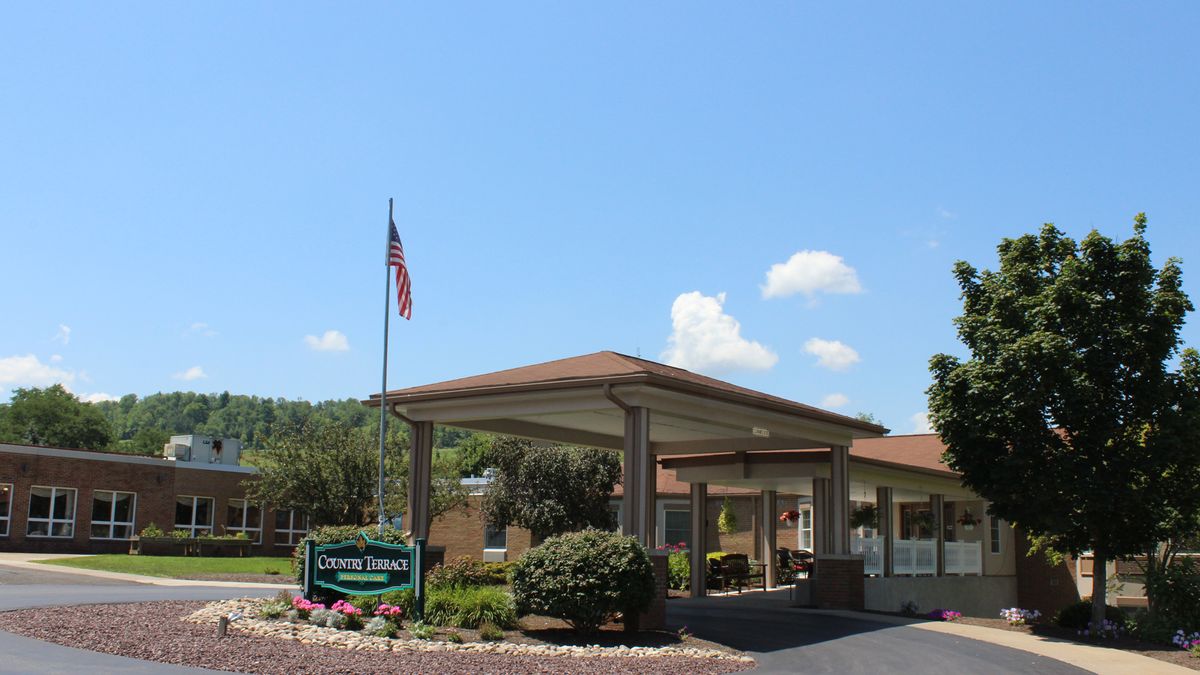 Entrance of a hotel with a prominent flagpole and landscaped surroundings.