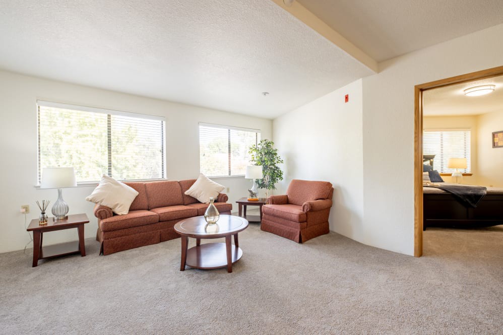 A bright living room with a sofa, armchair, and coffee table.