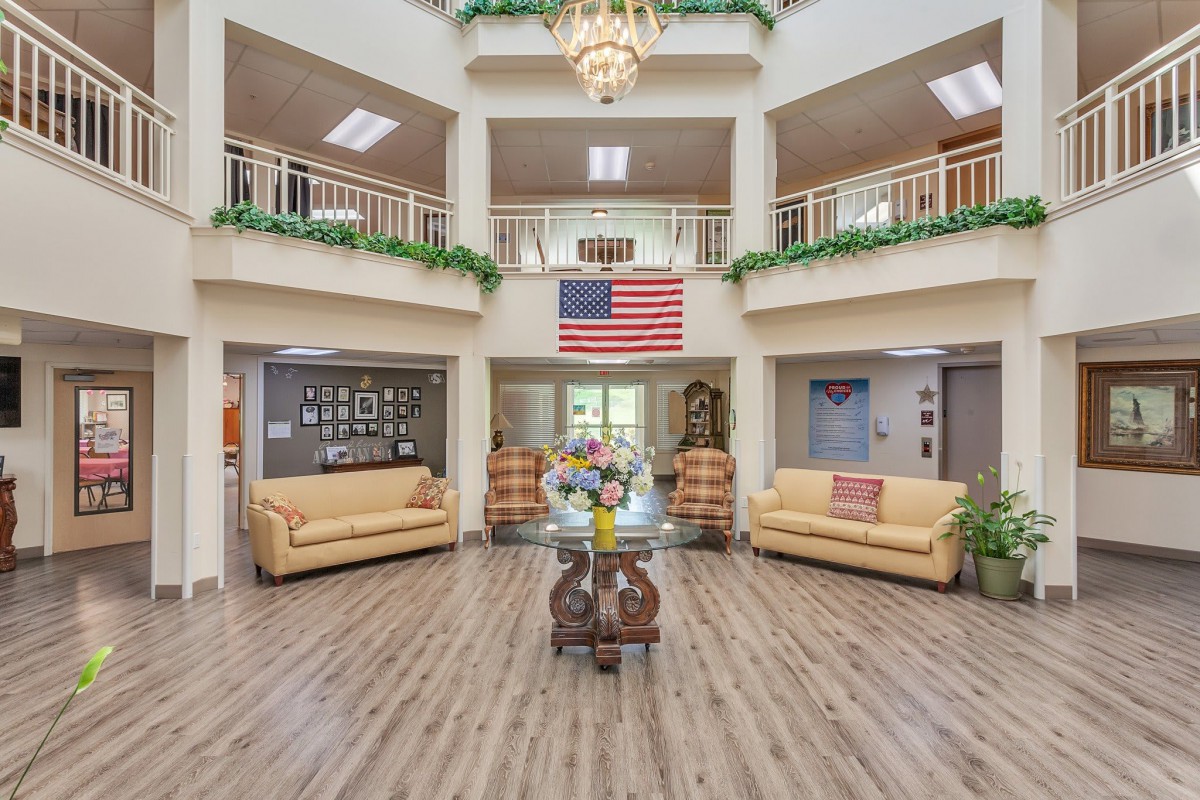 A spacious lobby with elegant decor, featuring an American flag and comfortable seating areas.
