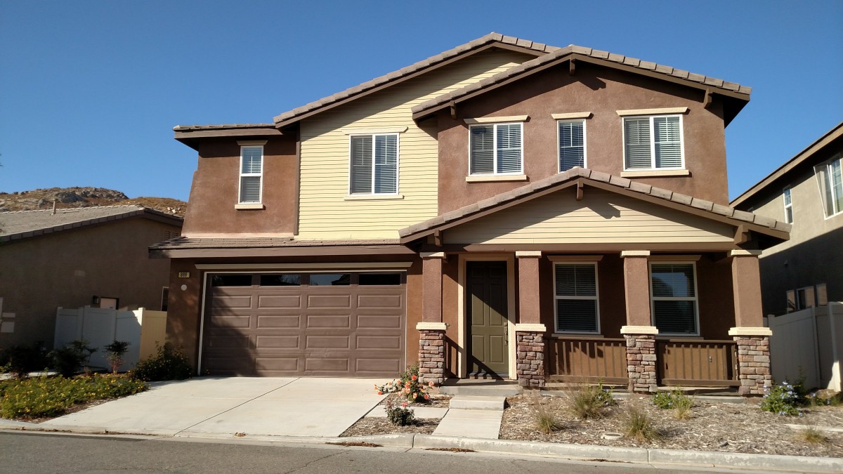 A modern two-story suburban house with a garage and front porch.