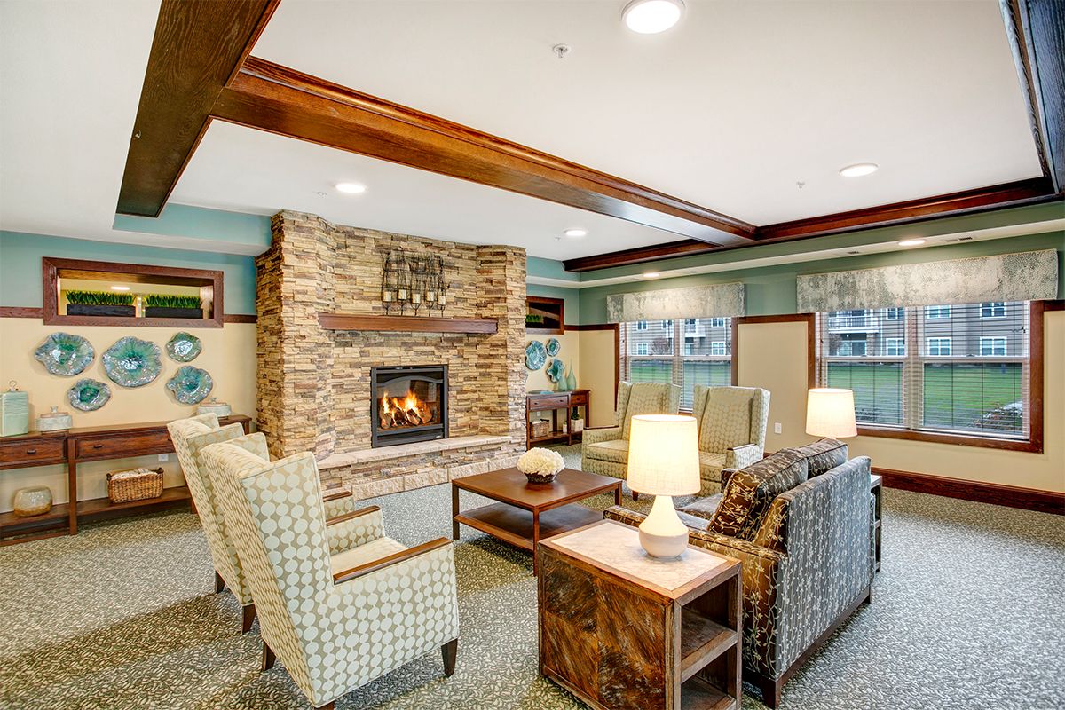 A cozy living room with a stone fireplace and comfortable seating.