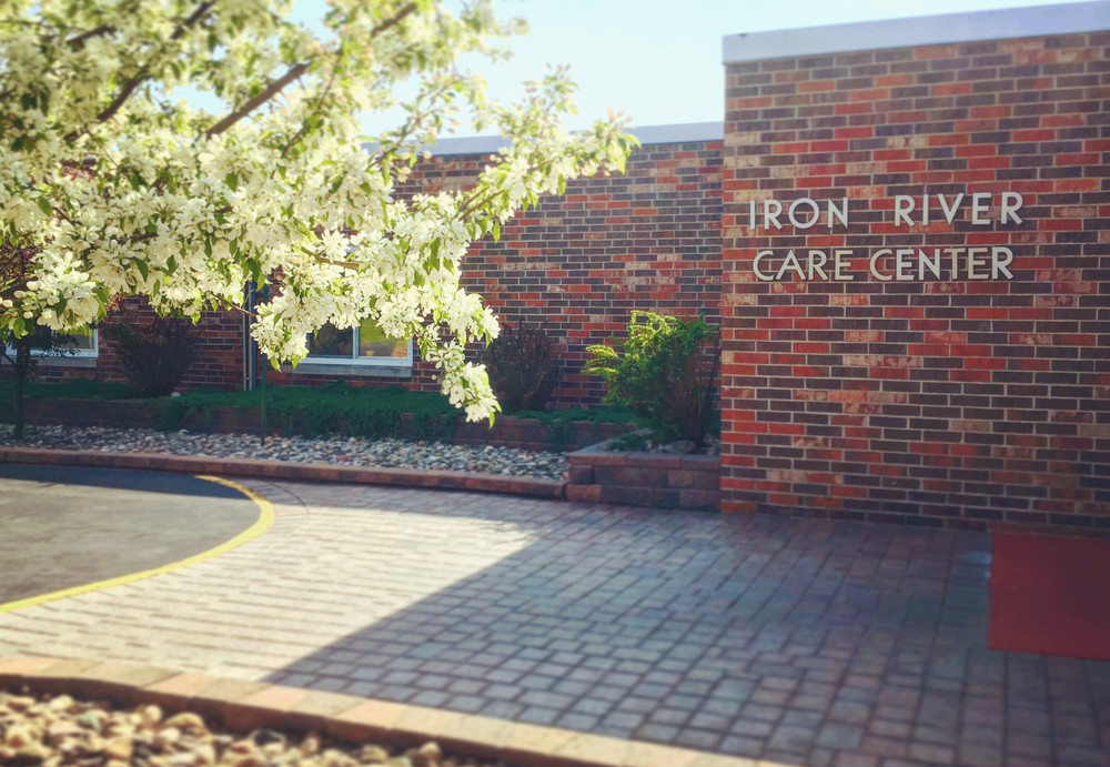 Entrance to a care center with brick facade and spring landscaping.