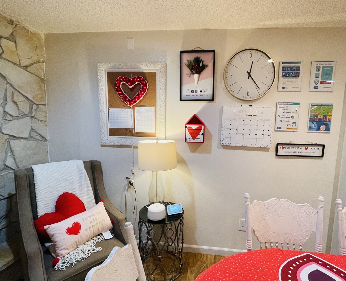 A cozy living room decorated with Valentine-themed items, including heart-shaped pillows and wall decor.
