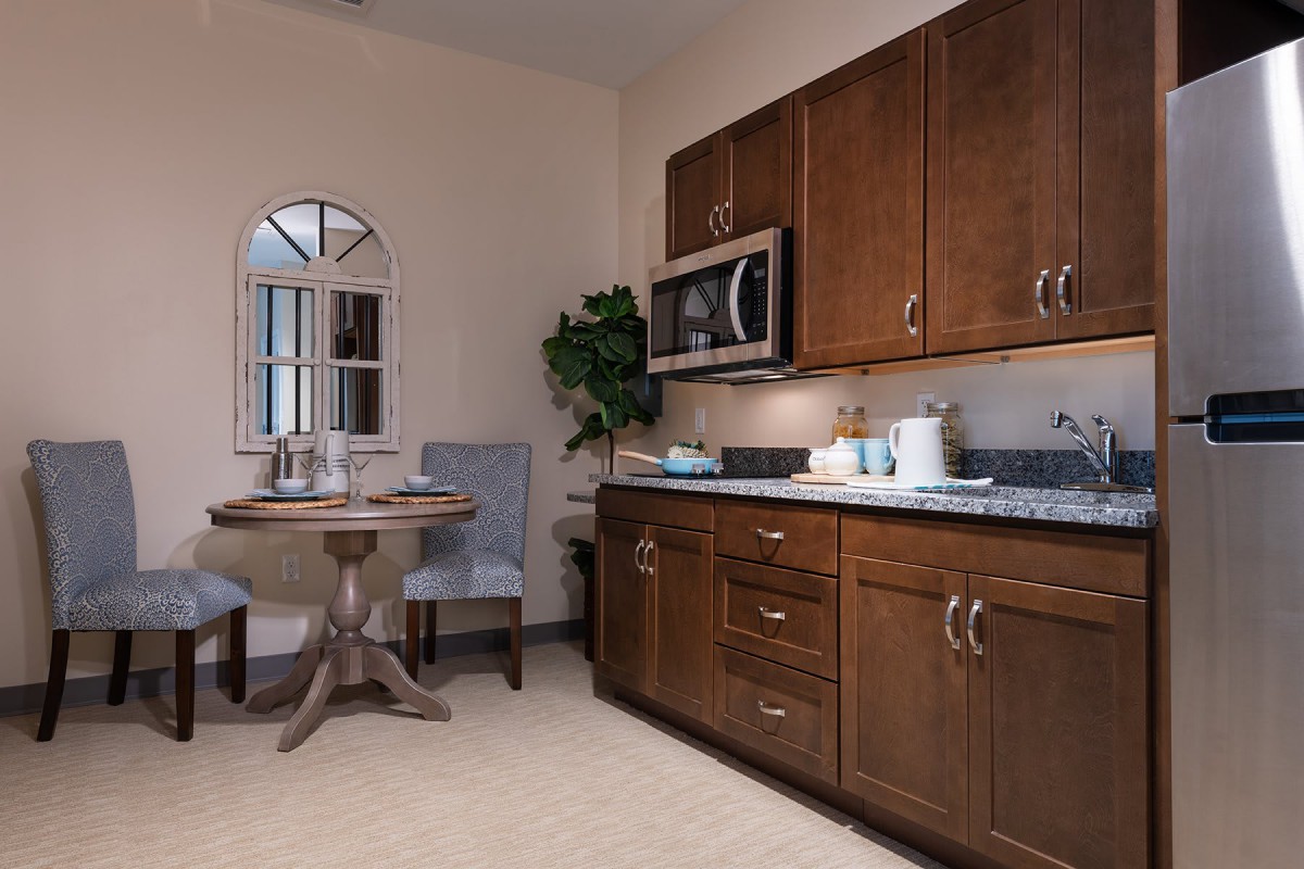 A cozy kitchen with wooden cabinets, a small dining area, and modern appliances.