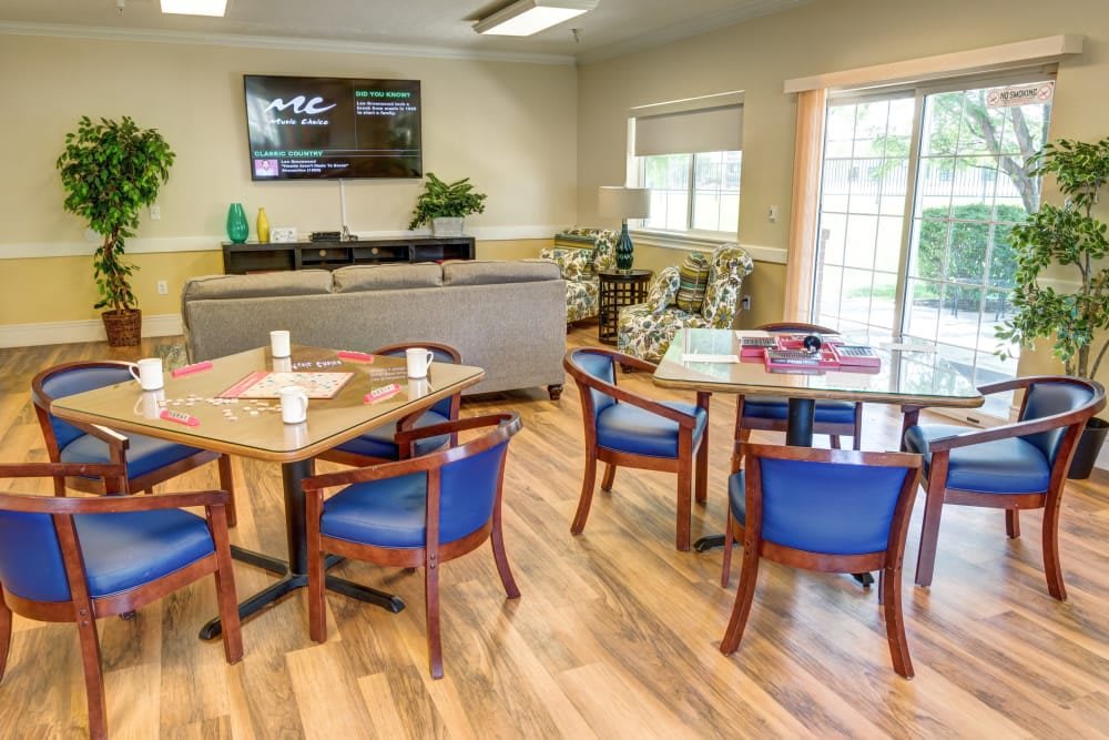 A cozy living room and dining area with comfortable seating, a TV, and wooden flooring.