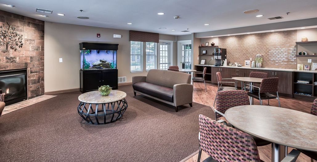 A modern living room with a sofa, coffee table, and aquarium.
