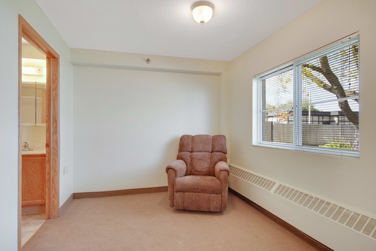 A minimalist room with a single armchair and a window.