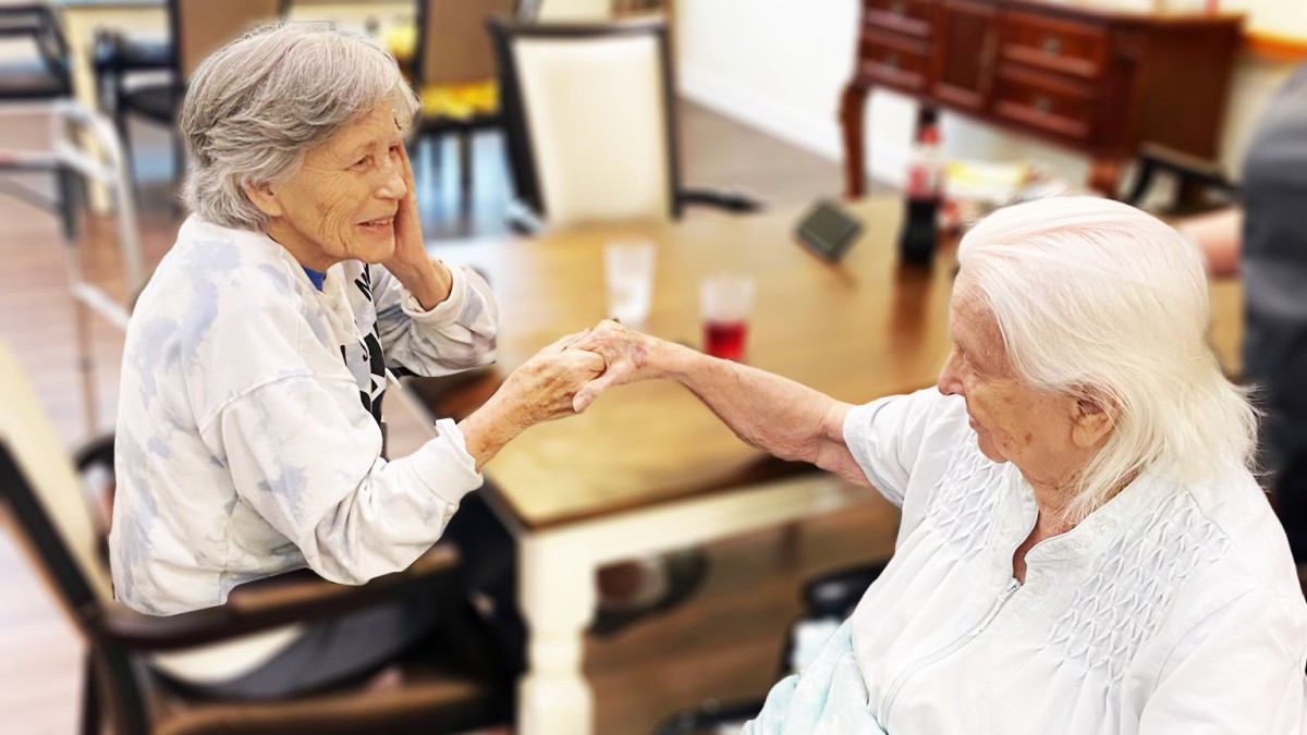 Two elderly individuals engaging in a friendly conversation, sharing a moment of companionship.