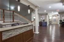 A modern lobby area featuring a wooden reception desk and staircase.