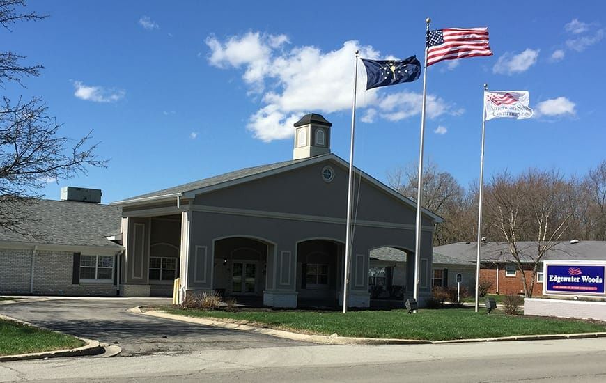 A building with several flags in front of it under a partly cloudy sky.