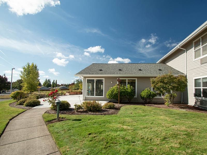 A suburban house with a well-maintained yard and a clear blue sky.