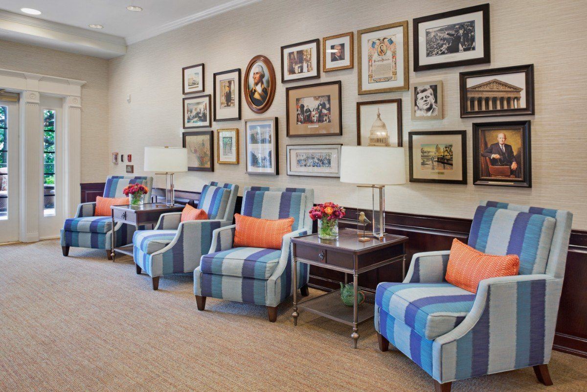 A cozy lounge area with striped chairs, colorful cushions, and an art gallery wall.