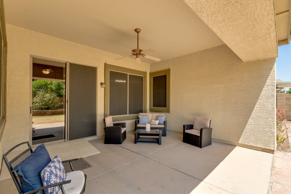 A cozy patio with comfortable seating and a ceiling fan for relaxation.