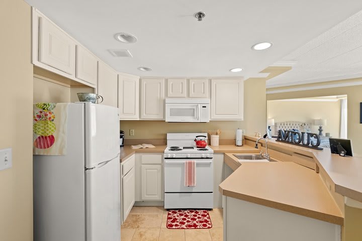 A bright and modern kitchen with white cabinets and appliances.