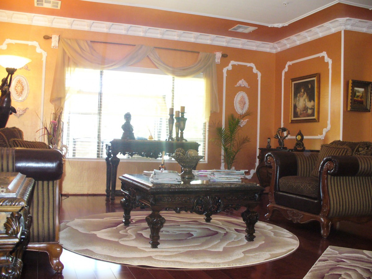 A cozy living room decorated in a classic style with ornate furniture and warm colors.