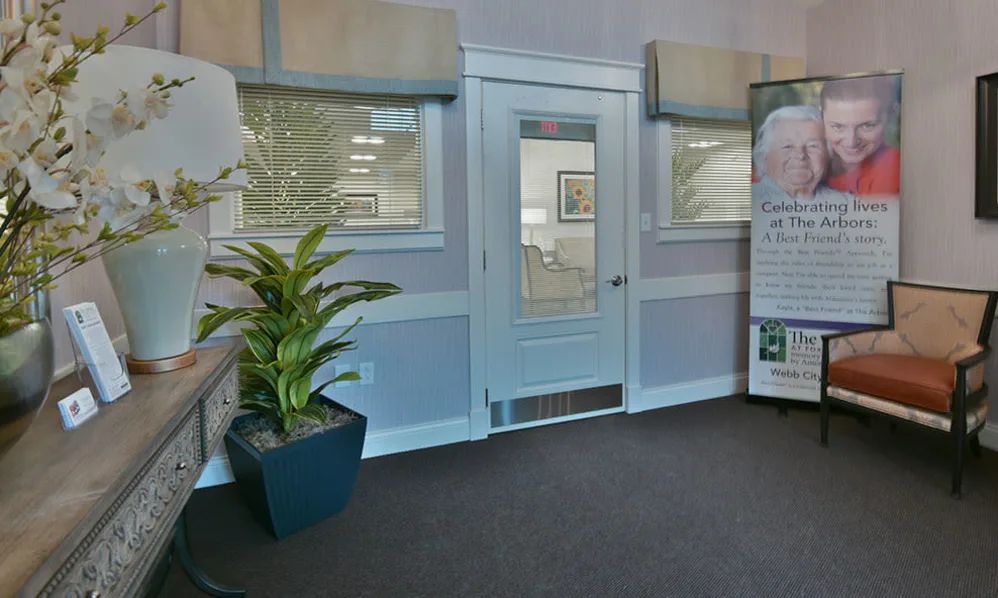 A reception area featuring a door, windows, and a large potted plant.