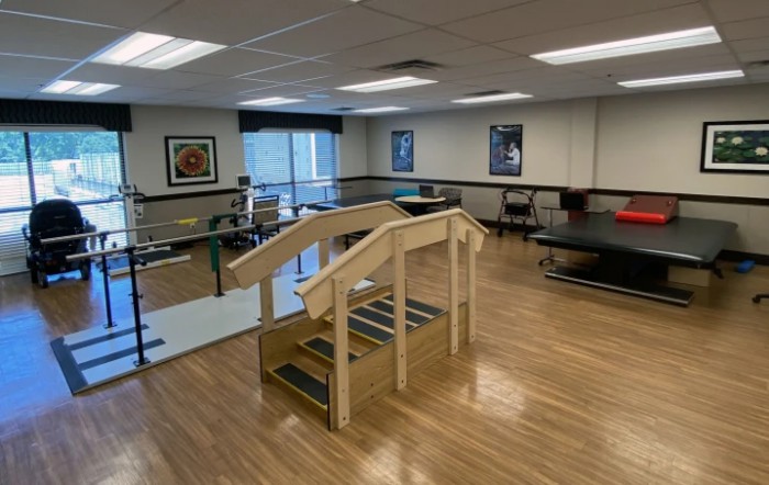 A well-equipped physical therapy room with exercise equipment and facilities.