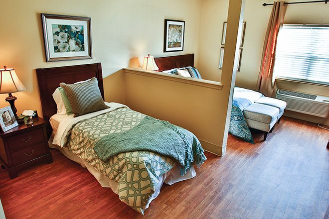 A cozy bedroom with two neatly made twin beds separated by a partial wall.