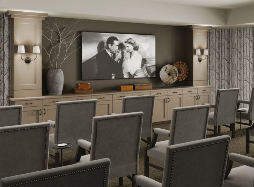 A cozy home theater setup with rows of chairs facing a large screen displaying a black and white movie.