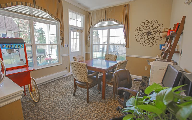A cozy dining room with a table, chairs, and large windows letting in natural light.