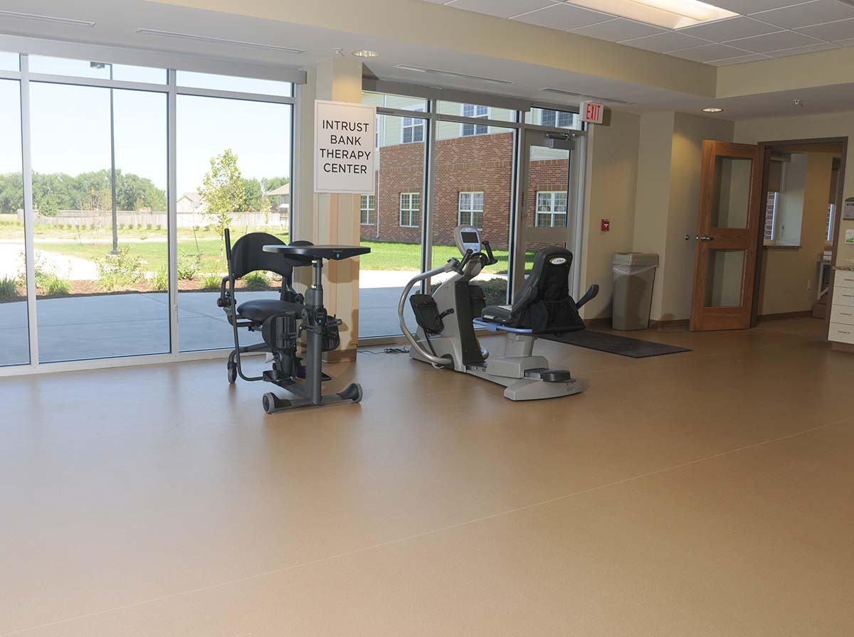 A well-lit fitness center with stationary bikes near large windows.