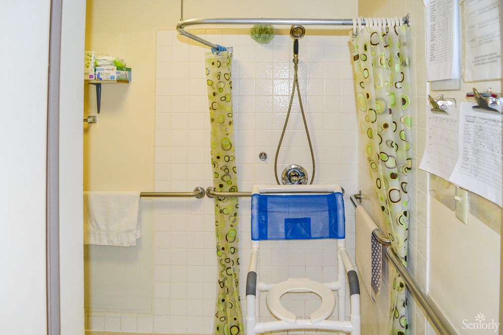 Accessible bathroom with shower chair and grab bars.