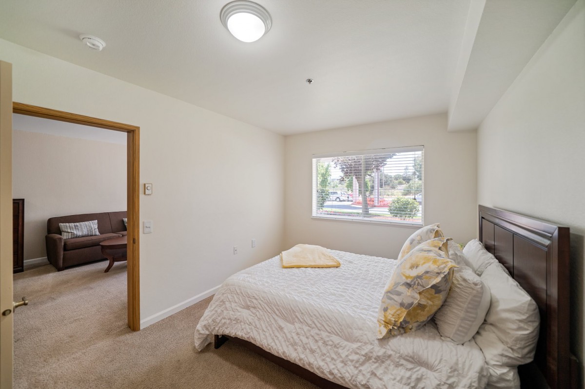 A minimalistic bedroom with a bed, window, and simple decor.