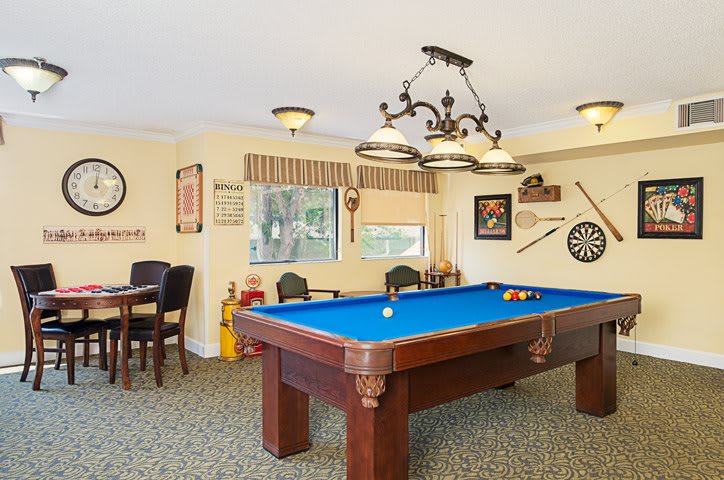 A cozy game room featuring a blue pool table and a dartboard for recreation.