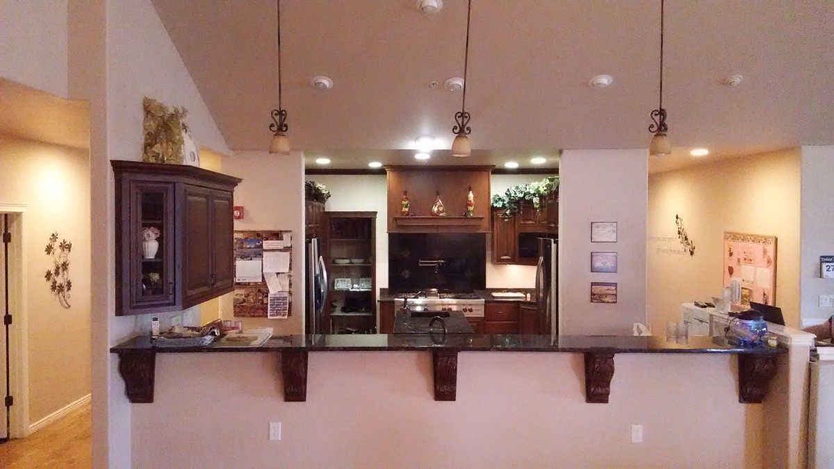 A modern kitchen with dark wood cabinetry and elegant lighting.