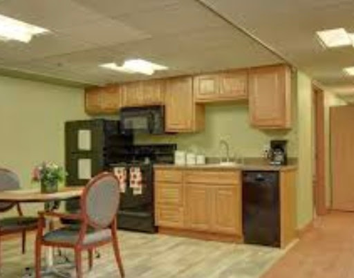 A cozy kitchen setup featuring modern black appliances and wooden cabinets, perfectly blending functionality with home comfort.