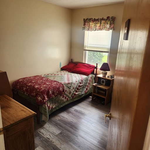 A cozy bedroom featuring a neatly made bed and warm decor.