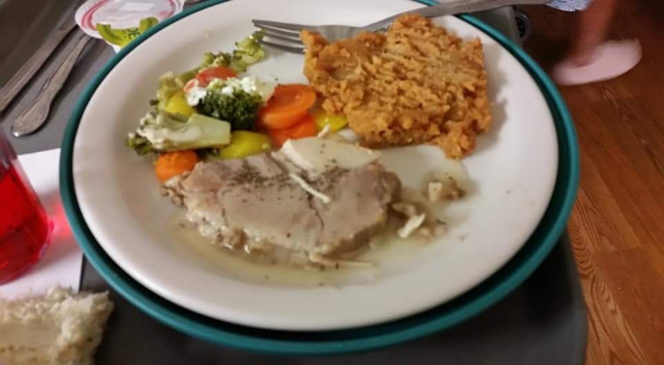 A plate of food with rice, vegetables, and meat in sauce.