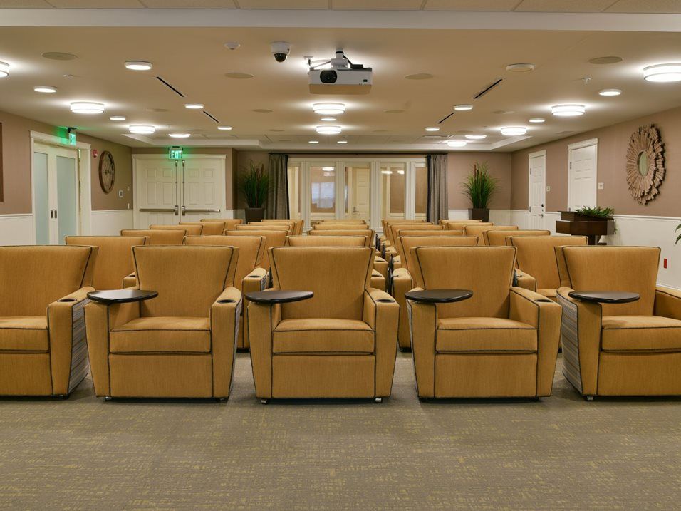 A well-arranged conference room with comfortable seating and a central projector for presentations.
