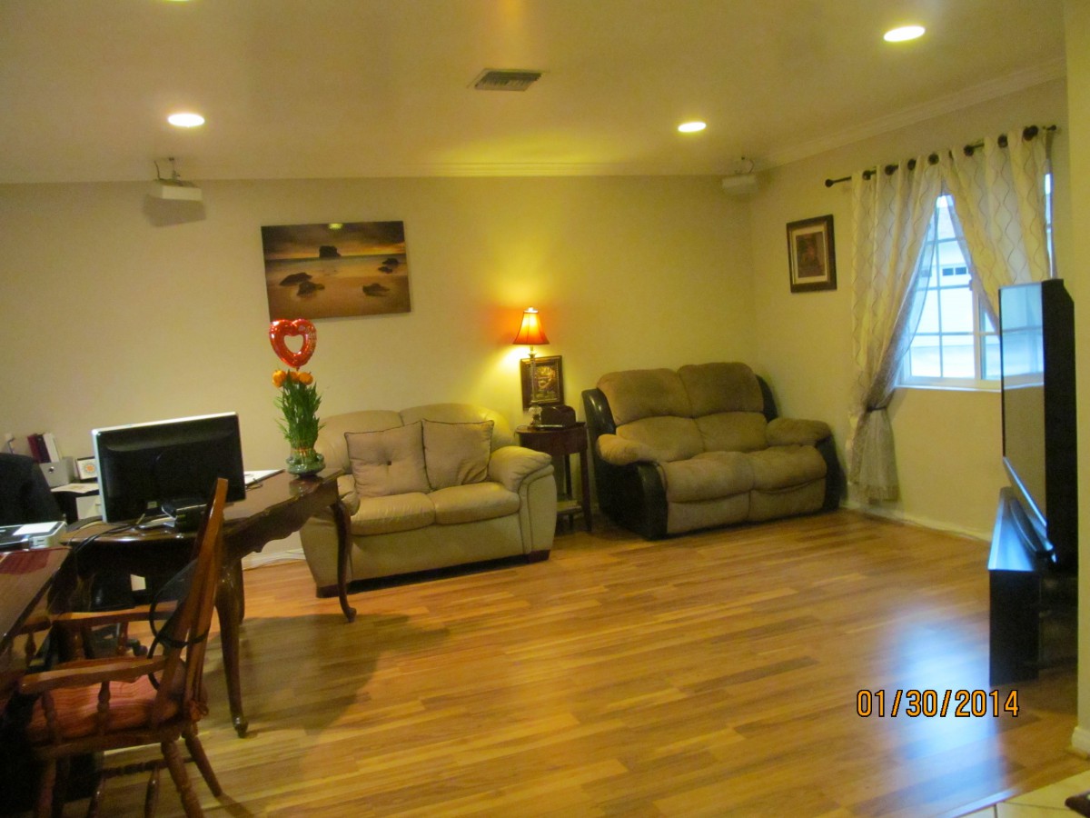 A cozy living room with sofas, a television, and warm lighting.