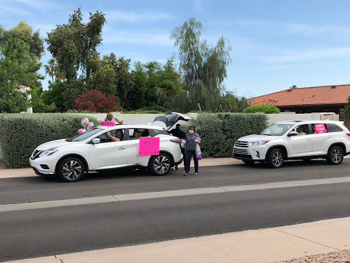 A community gathering with decorated cars and cheerful participants.