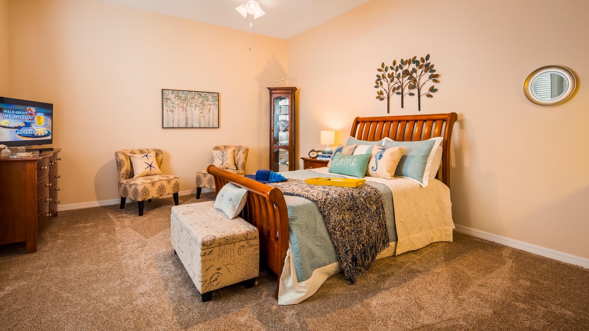 A cozy bedroom interior with a wooden bed, colorful bedding, and elegant decor.