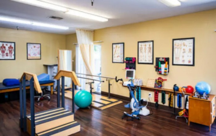 A physical therapy room equipped with exercise machines and tools for rehabilitation.
