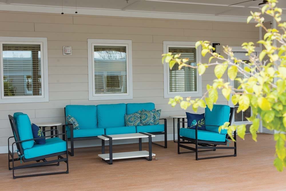 Outdoor patio area with blue cushioned furniture and a wooden deck.