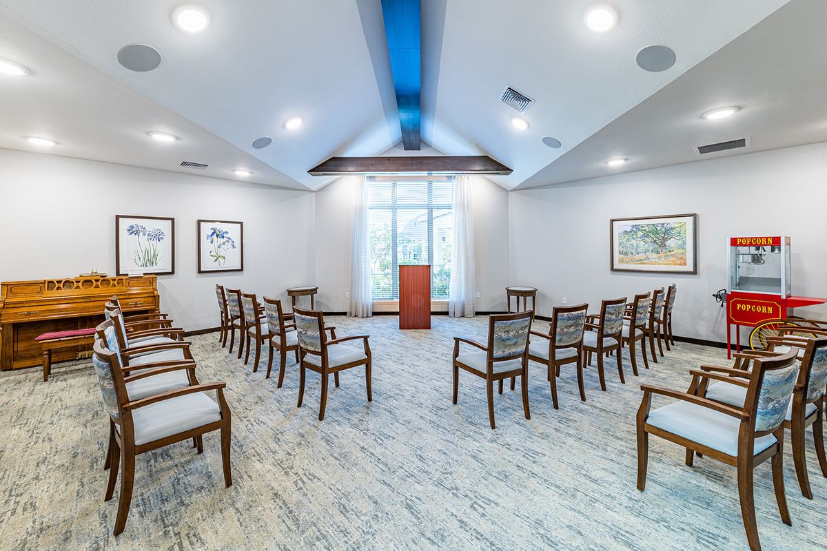 A well-lit meeting room set up with chairs facing a podium, ready for a conference or presentation.