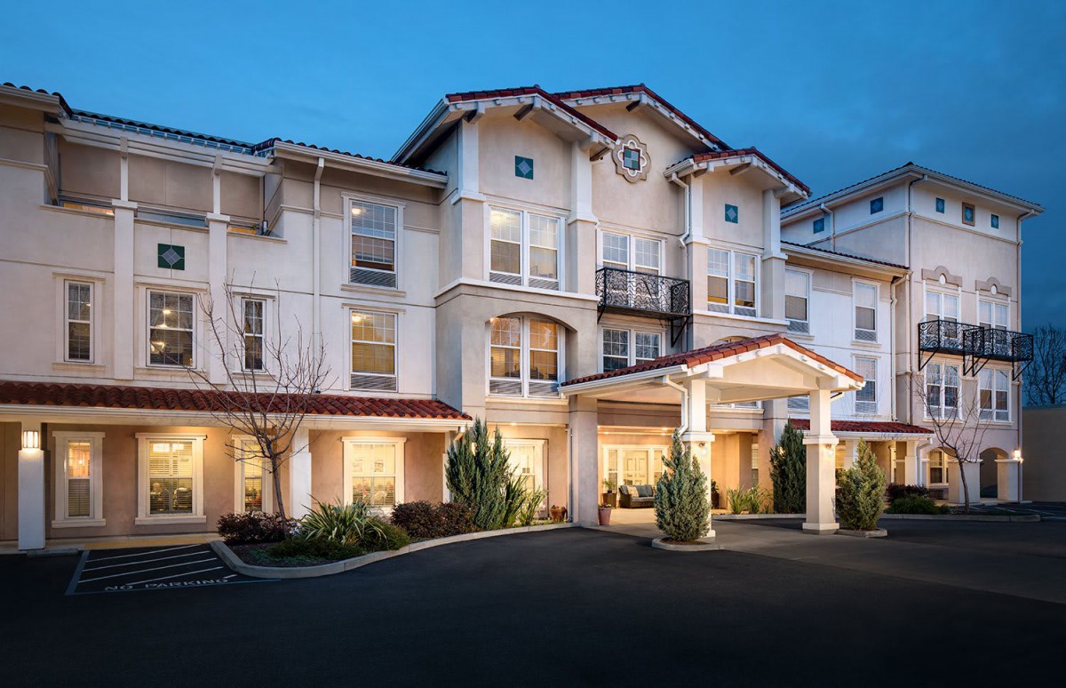 A residential building with a welcoming entrance lit up in the evening.