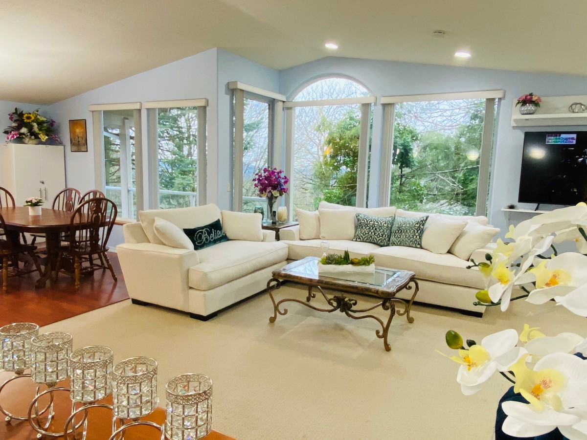 A bright and spacious living room featuring a comfortable sectional sofa, elegant coffee table, and large windows that allow natural light to fill the space.