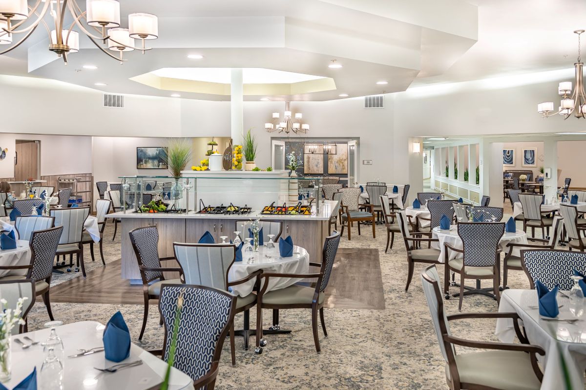 A spacious and elegantly decorated dining area with neatly arranged tables and chairs.