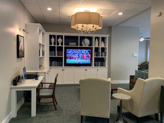 A cozy living room featuring a television, shelving unit, and comfortable seating.