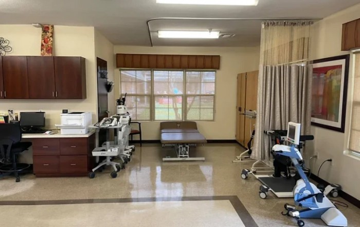 A medical treatment room equipped with various machines and furniture.