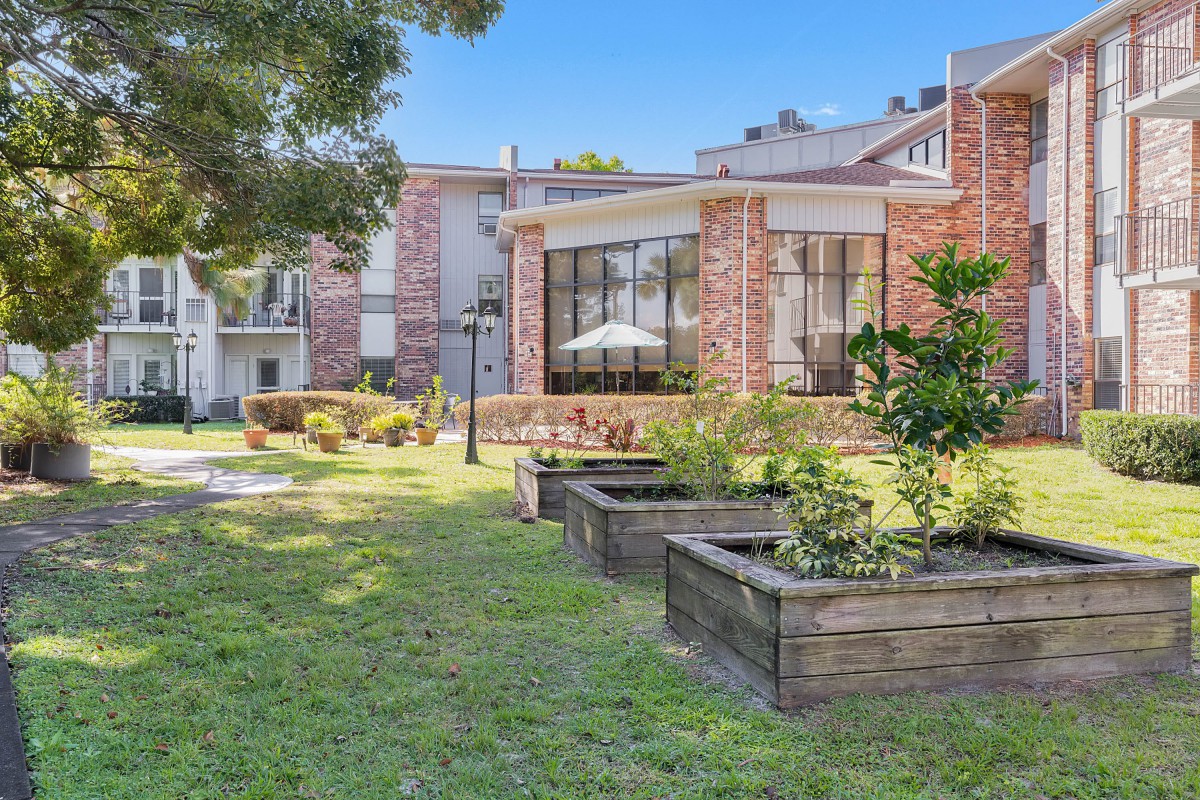 A scenic view of a courtyard with lush greenery and modern buildings.