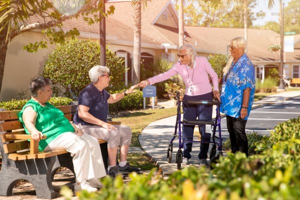 A group of seniors socializing outside in a retirement community.