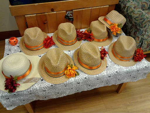 A colorful array of decorative hats arranged on a table, perfect for summer outings.