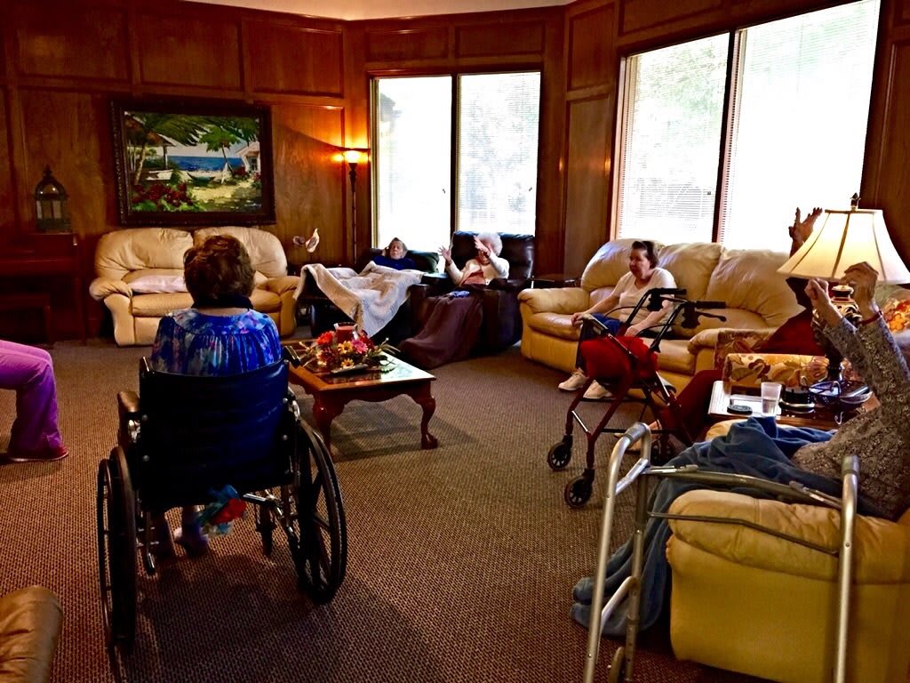 Elderly residents relaxing in a cozy living room setting at a nursing home.