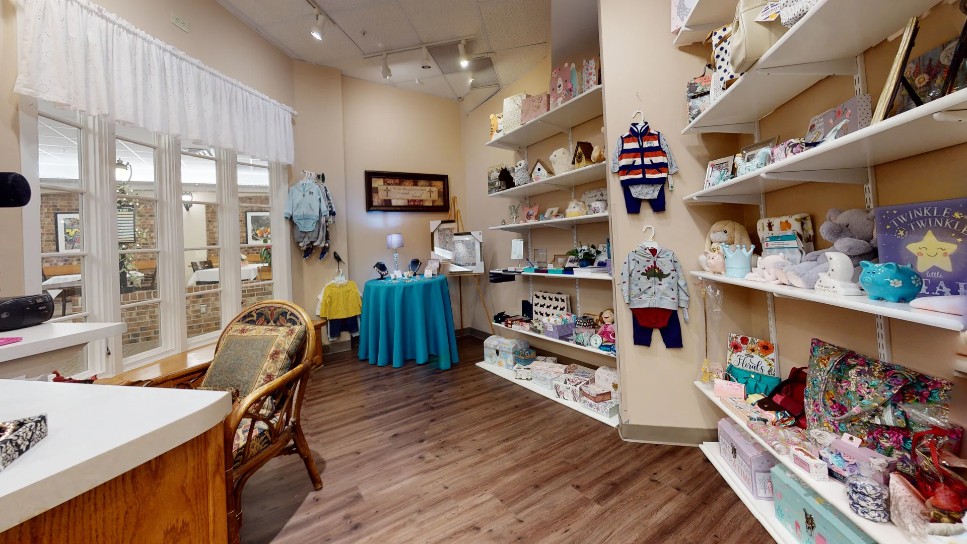 A cozy baby boutique featuring children's clothing and toys displayed on shelves.